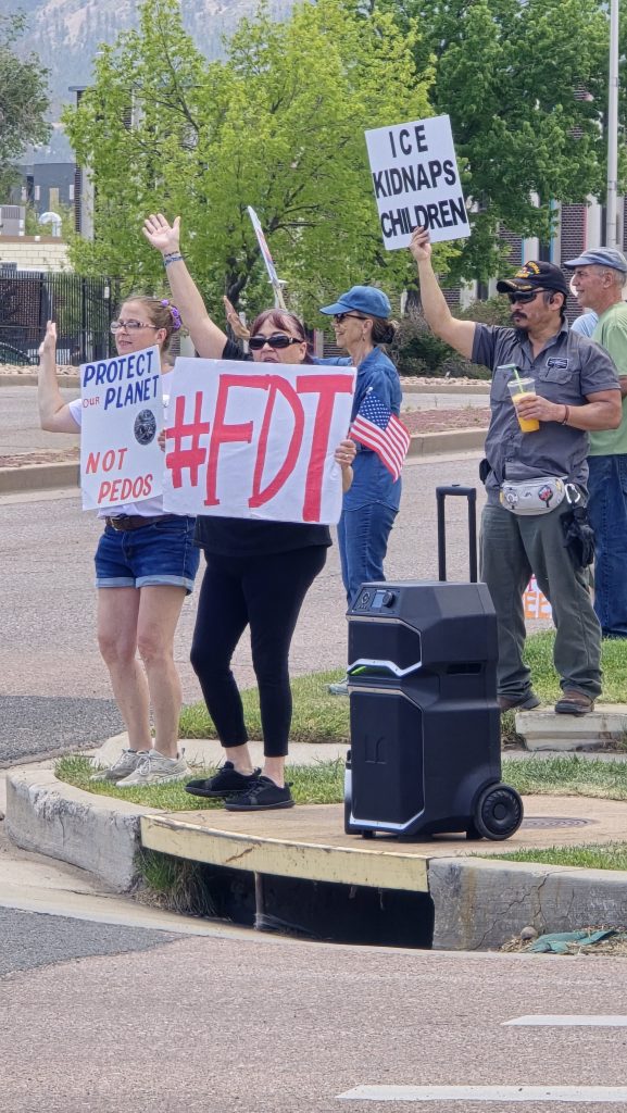 Weekly protesters with signs gathered in front of Rep. Jeff Crank’s Colorado Springs office on Pikes Peak Avenue